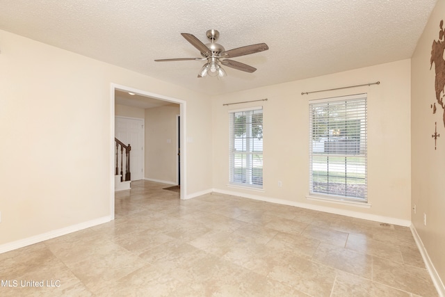 empty room featuring a textured ceiling and ceiling fan