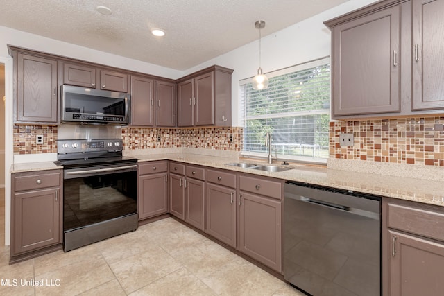 kitchen with tasteful backsplash, sink, a textured ceiling, stainless steel appliances, and pendant lighting