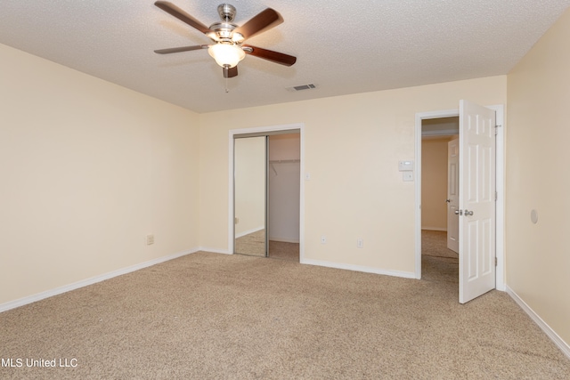 unfurnished bedroom with light carpet, a closet, a textured ceiling, and ceiling fan