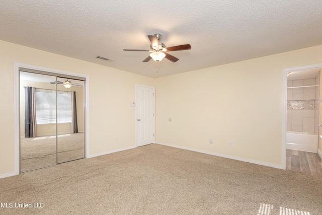 carpeted spare room with a textured ceiling and ceiling fan