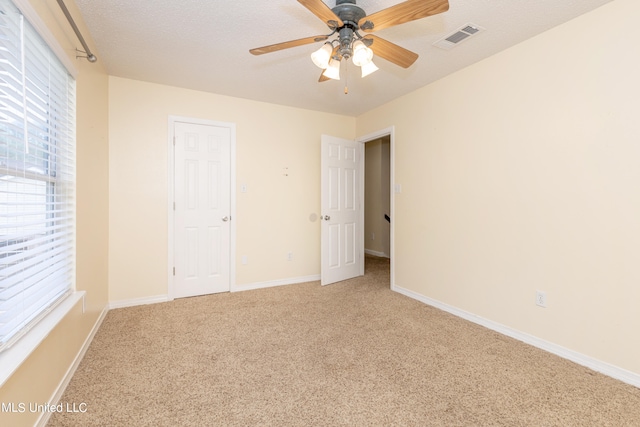 unfurnished bedroom featuring a textured ceiling, carpet floors, and ceiling fan