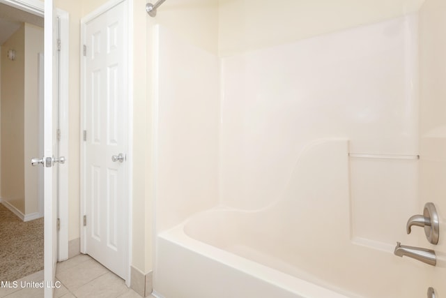 bathroom with washtub / shower combination and tile patterned flooring