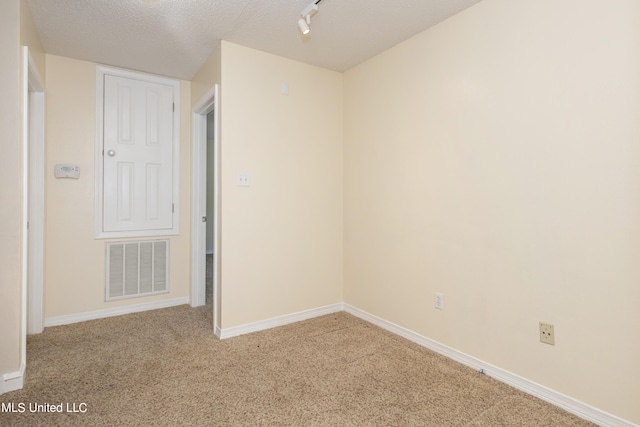 empty room with a textured ceiling and carpet floors