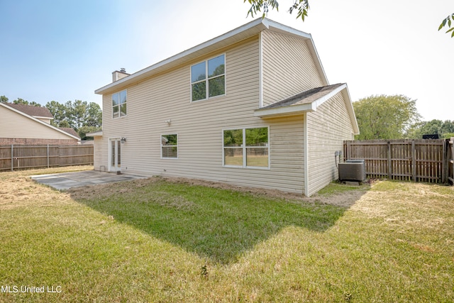 back of property with a yard, central air condition unit, and a patio