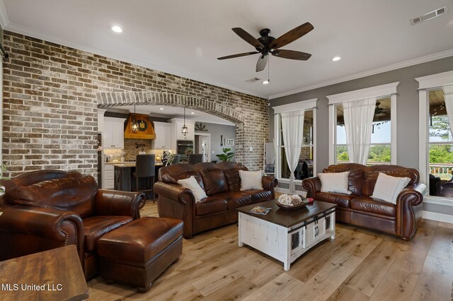 446 Newman Camp Rd, Sumrall, MS 39482 - living area with a ceiling fan, light wood-type flooring, ornamental molding, brick wall, and arched walkways