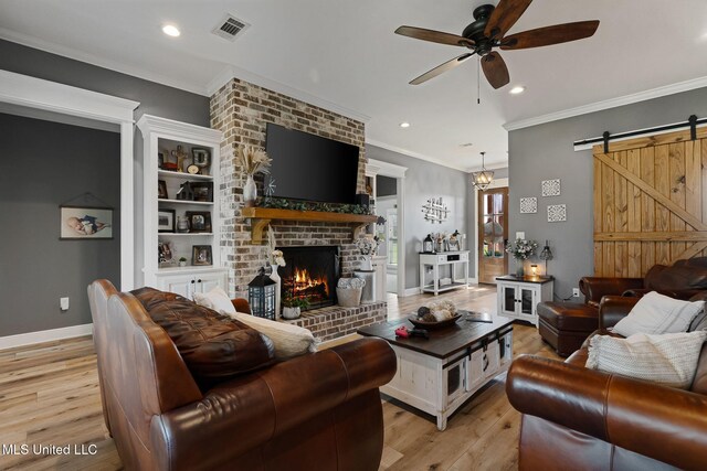 446 Newman Camp Rd, Sumrall, MS 39482 - living area with a barn door, ceiling fan, light wood-style floors, a fireplace, and crown molding
