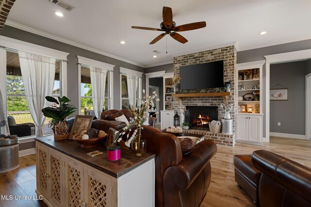 446 Newman Camp Rd, Sumrall, MS 39482 - living area with light wood-style floors, a ceiling fan, a brick fireplace, baseboards, and crown molding