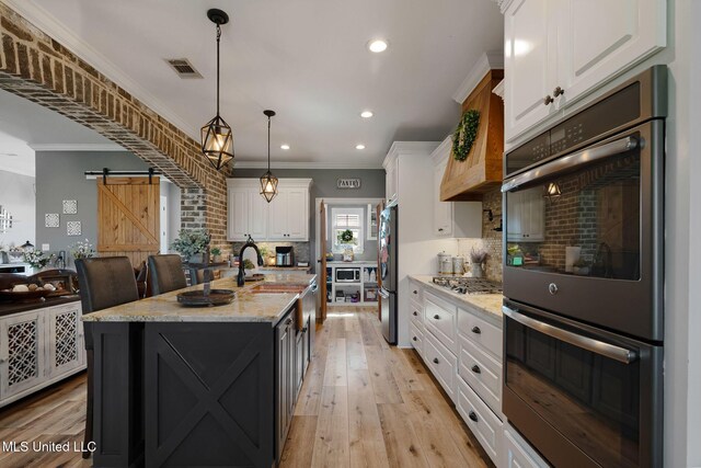 446 Newman Camp Rd, Sumrall, MS 39482 - kitchen featuring stainless steel appliances, a barn door, white cabinets, decorative backsplash, and recessed lighting