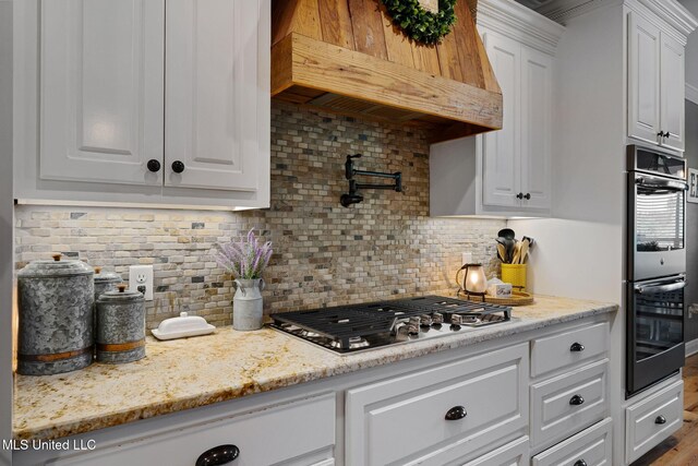 446 Newman Camp Rd, Sumrall, MS 39482 - kitchen featuring stainless steel appliances, white cabinetry, tasteful backsplash, and custom range hood