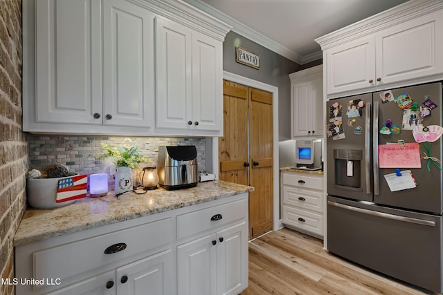 446 Newman Camp Rd, Sumrall, MS 39482 - kitchen featuring stainless steel refrigerator with ice dispenser, white cabinetry, ornamental molding, and light wood-style flooring