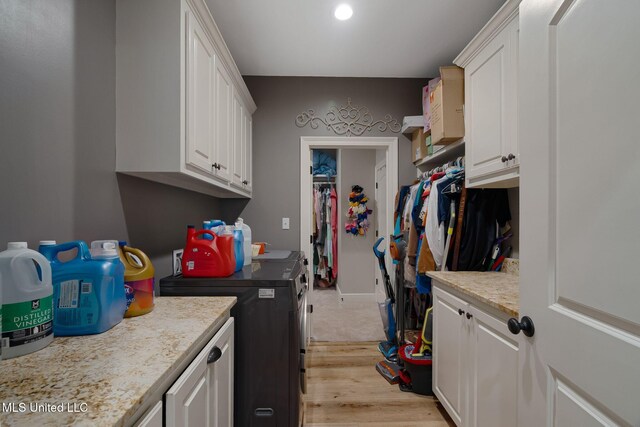 446 Newman Camp Rd, Sumrall, MS 39482 - washroom featuring washer and clothes dryer, cabinet space, and light wood-type flooring