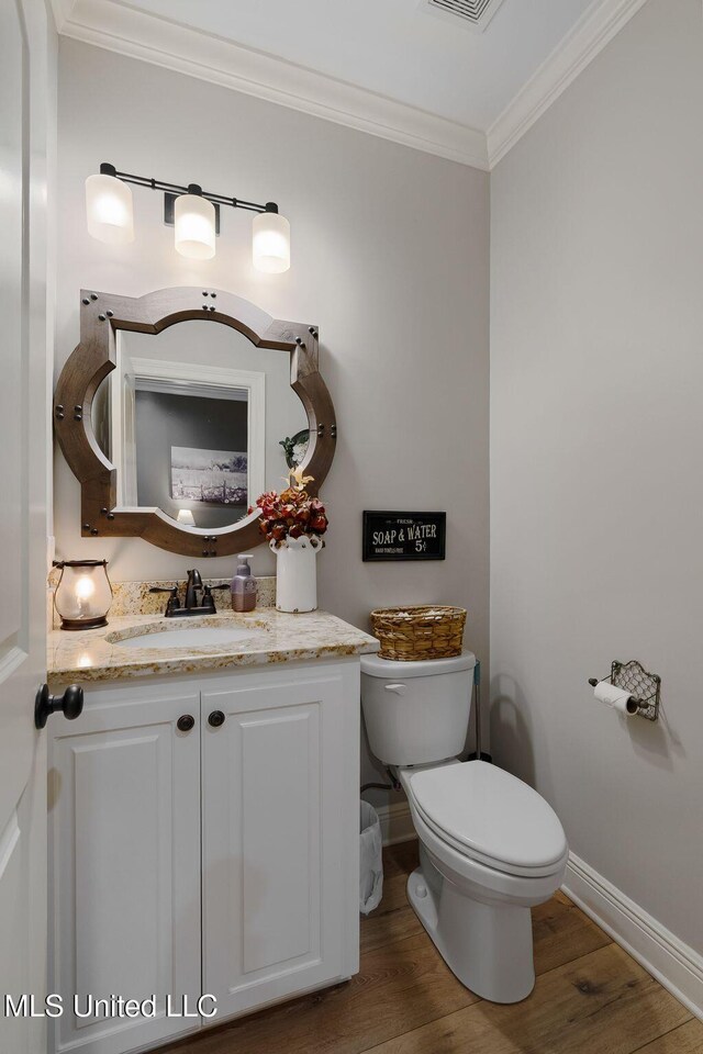 446 Newman Camp Rd, Sumrall, MS 39482 - half bathroom with crown molding, wood finished floors, vanity, toilet, and baseboards