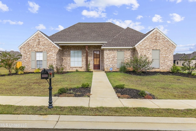 962 Glenwild Cir, Canton, MS 39046 - view of front of home with brick siding, a front lawn, and a shingled roof
