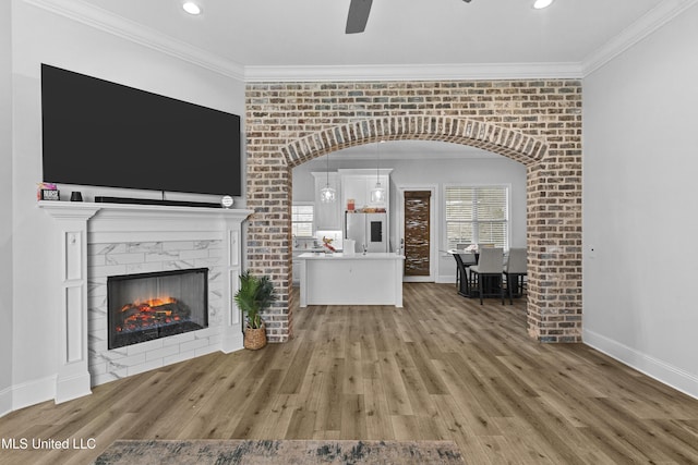 962 Glenwild Cir, Canton, MS 39046 - unfurnished living room with crown molding, a ceiling fan, light wood-style flooring, a high end fireplace, and baseboards