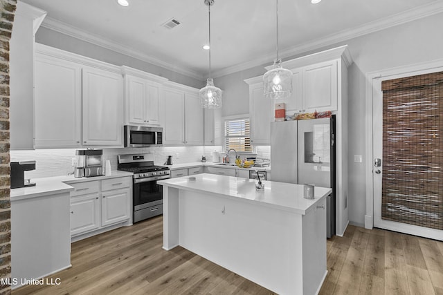 962 Glenwild Cir, Canton, MS 39046 - kitchen featuring appliances with stainless steel finishes, a sink, white cabinets, light wood-type flooring, and recessed lighting