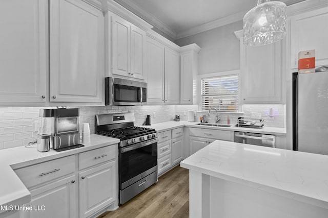 962 Glenwild Cir, Canton, MS 39046 - kitchen featuring appliances with stainless steel finishes, a sink, white cabinets, ornamental molding, and backsplash