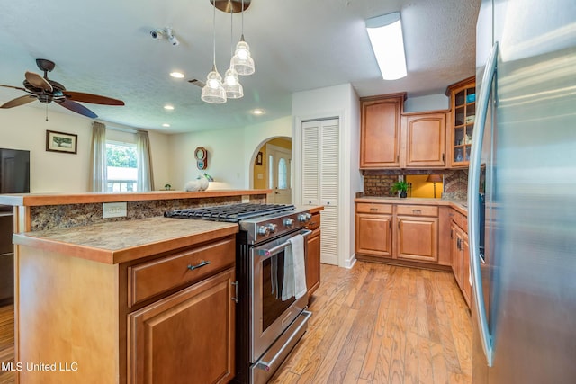 109 Boggs Cir, Long Beach, MS 39560 - kitchen featuring appliances with stainless steel finishes, arched walkways, light wood-type flooring, backsplash, and recessed lighting