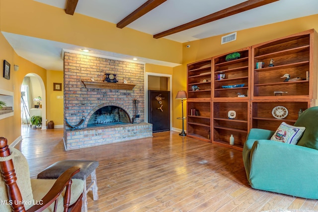 109 Boggs Cir, Long Beach, MS 39560 - living room with arched walkways, a fireplace, beamed ceiling, and wood finished floors