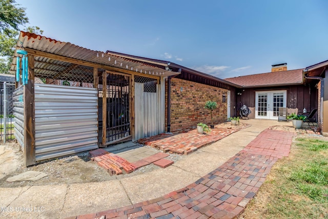 109 Boggs Cir, Long Beach, MS 39560 - entrance to property with french doors, board and batten siding, brick siding, and a chimney