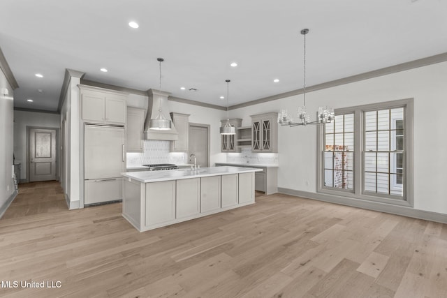 kitchen featuring paneled built in fridge, premium range hood, backsplash, baseboards, and ornamental molding