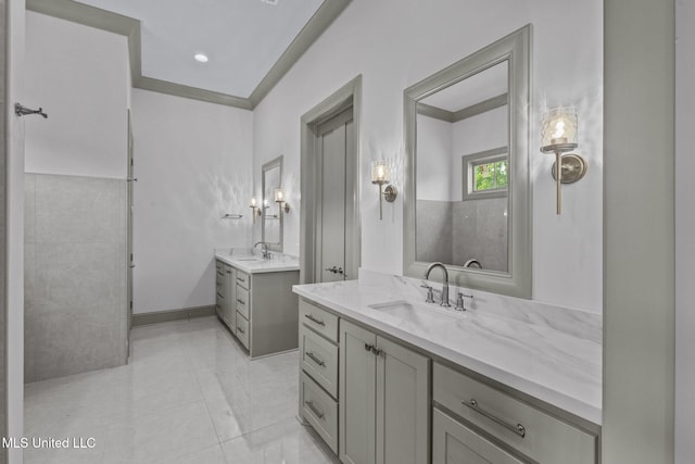 bathroom featuring two vanities, baseboards, and tile patterned floors
