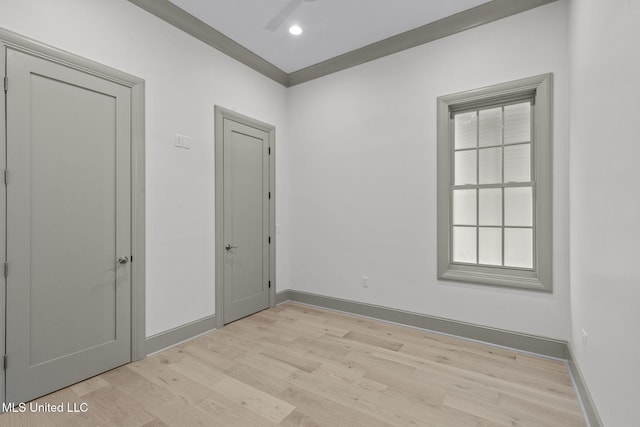 unfurnished bedroom with light wood-style flooring, baseboards, and multiple windows