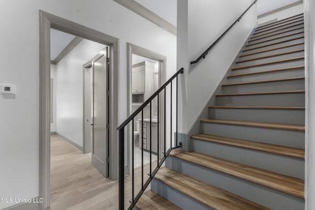stairs with wood finished floors and baseboards