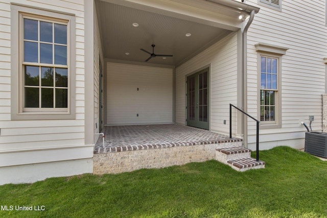 property entrance featuring ceiling fan, a yard, and cooling unit