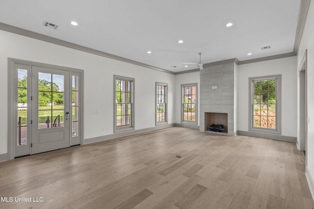 unfurnished living room featuring healthy amount of natural light, ornamental molding, light wood-style flooring, recessed lighting, and baseboards