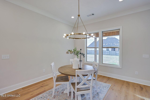 dining room featuring light hardwood / wood-style floors, a notable chandelier, and ornamental molding