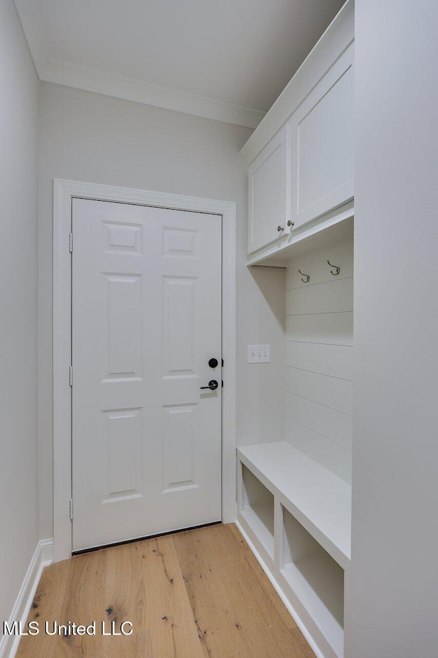 mudroom with light hardwood / wood-style flooring and crown molding