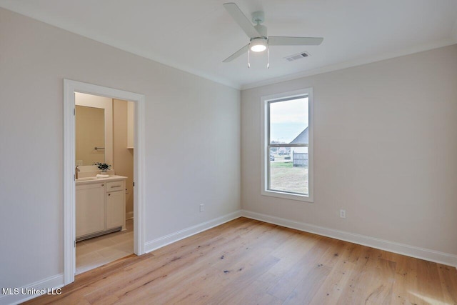 unfurnished bedroom with sink, ornamental molding, ensuite bath, and light hardwood / wood-style flooring