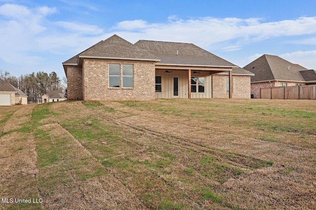 rear view of house with a lawn and ceiling fan