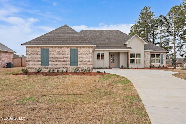 view of front of home with central AC and a front yard