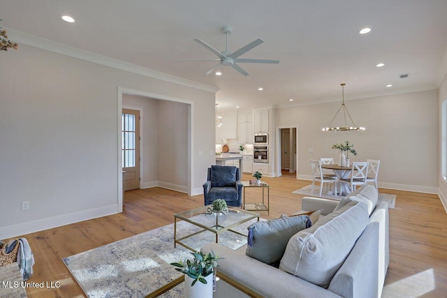 living room featuring ceiling fan with notable chandelier, light hardwood / wood-style flooring, and crown molding