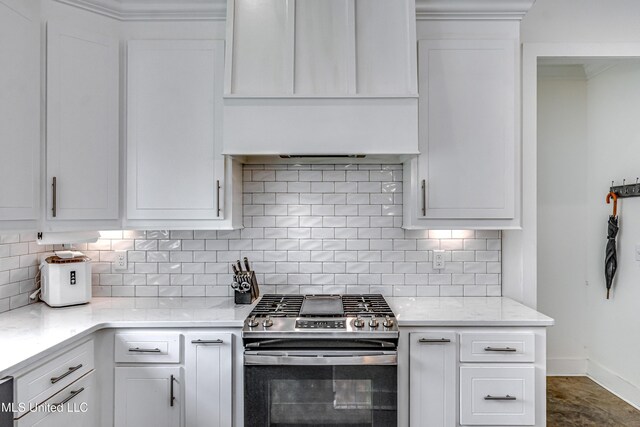 625 Wild Horse Ln, Brandon, MS 39042 - kitchen featuring gas range, wall chimney range hood, decorative backsplash, white cabinets, and crown molding