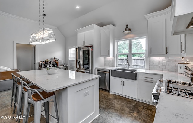625 Wild Horse Ln, Brandon, MS 39042 - kitchen with stainless steel appliances, a kitchen island, tasteful backsplash, white cabinetry, and lofted ceiling