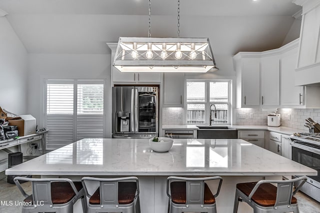 625 Wild Horse Ln, Brandon, MS 39042 - kitchen with stainless steel appliances, tasteful backsplash, lofted ceiling, plenty of natural light, and a breakfast bar area