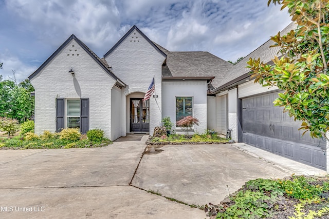 625 Wild Horse Ln, Brandon, MS 39042 - view of front of house with an attached garage, concrete driveway, brick siding, and french doors