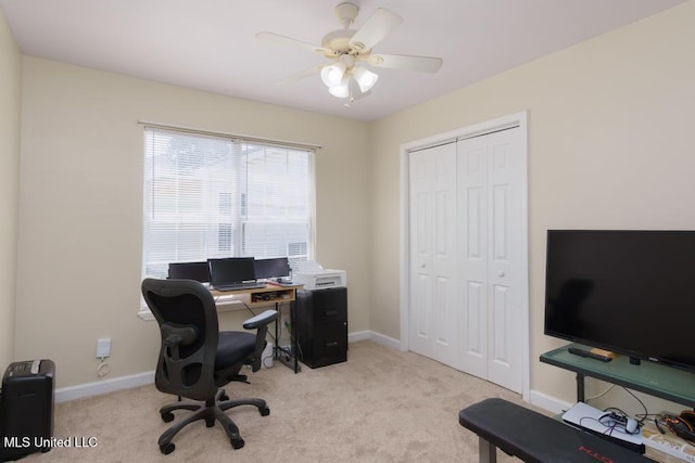 office area featuring light colored carpet, baseboards, and a ceiling fan