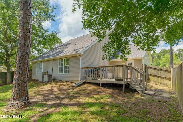 back of property with roof with shingles, a deck, and a fenced backyard