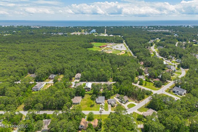aerial overview of property's location with a heavily wooded area and a large body of water