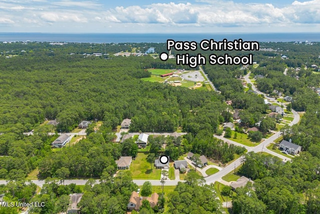 aerial view of property and surrounding area featuring a forest and a large body of water