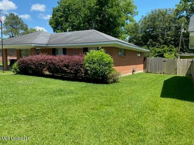 view of side of home with a lawn