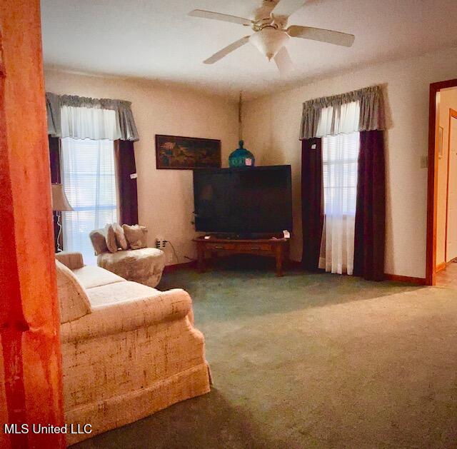 living room featuring carpet flooring and ceiling fan