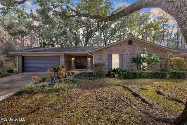 view of front of home featuring a garage, driveway, and brick siding