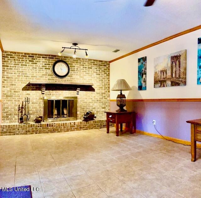 tiled living room featuring crown molding and a brick fireplace