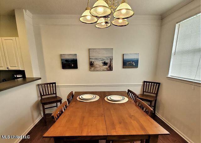 2252 Beach Dr Unit 1704, Gulfport, MS 39501 - dining space featuring a chandelier, dark wood finished floors, and ornamental molding