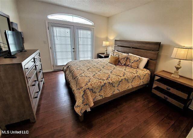 2252 Beach Dr Unit 1704, Gulfport, MS 39501 - bedroom with dark wood-style floors, access to outside, french doors, and a textured ceiling