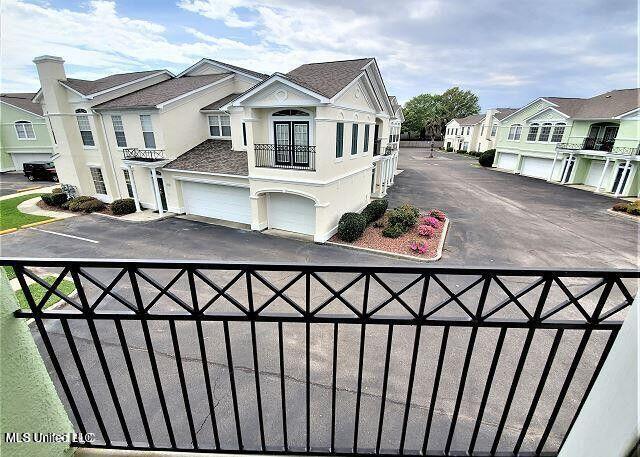 2252 Beach Dr Unit 1704, Gulfport, MS 39501 - view of front of home with a residential view, a balcony, stucco siding, a garage, and asphalt driveway